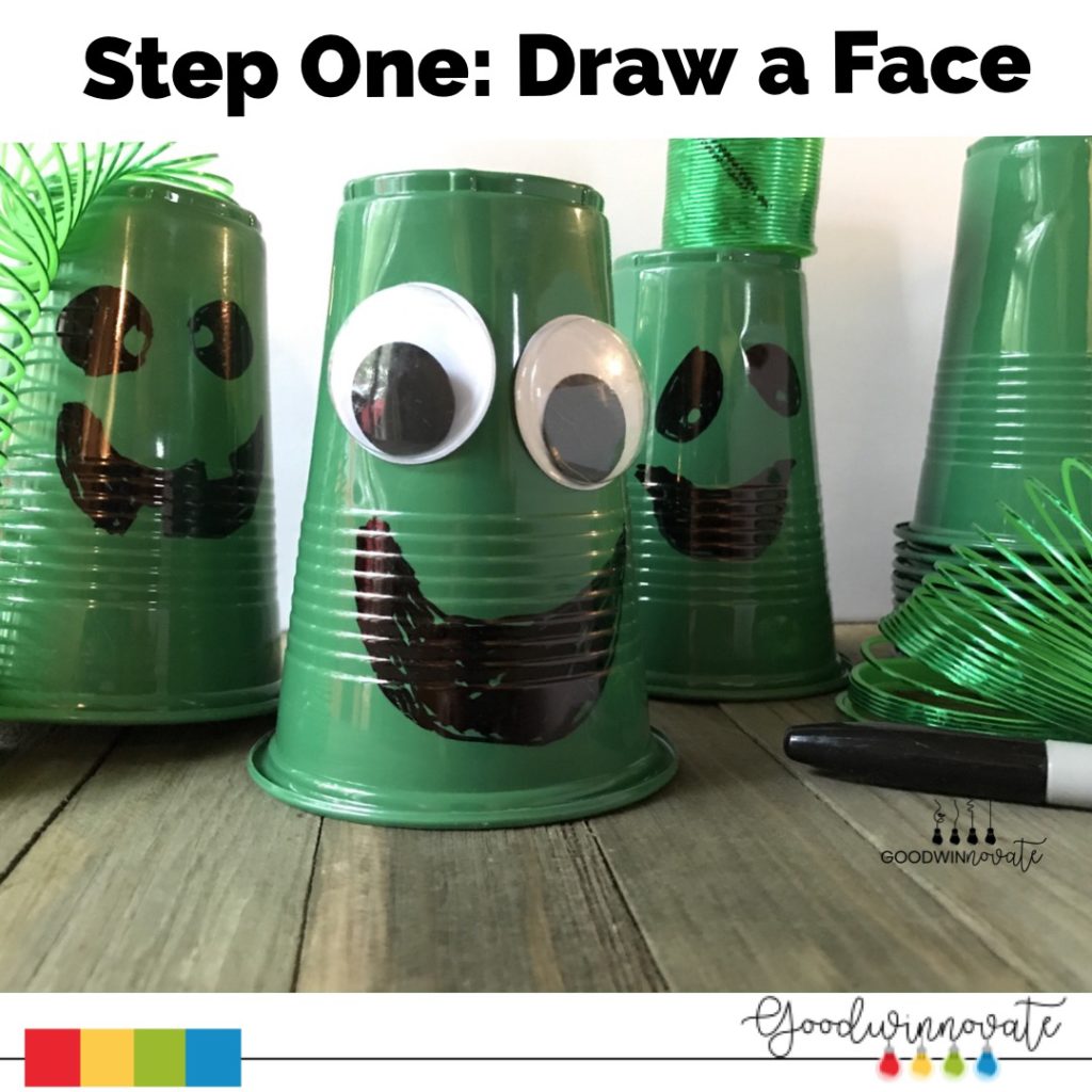 green cups with faces drawn on them with black sharpie to film on green screen