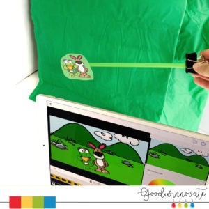 puppet in front of green plastic table cloth for a mini green screen